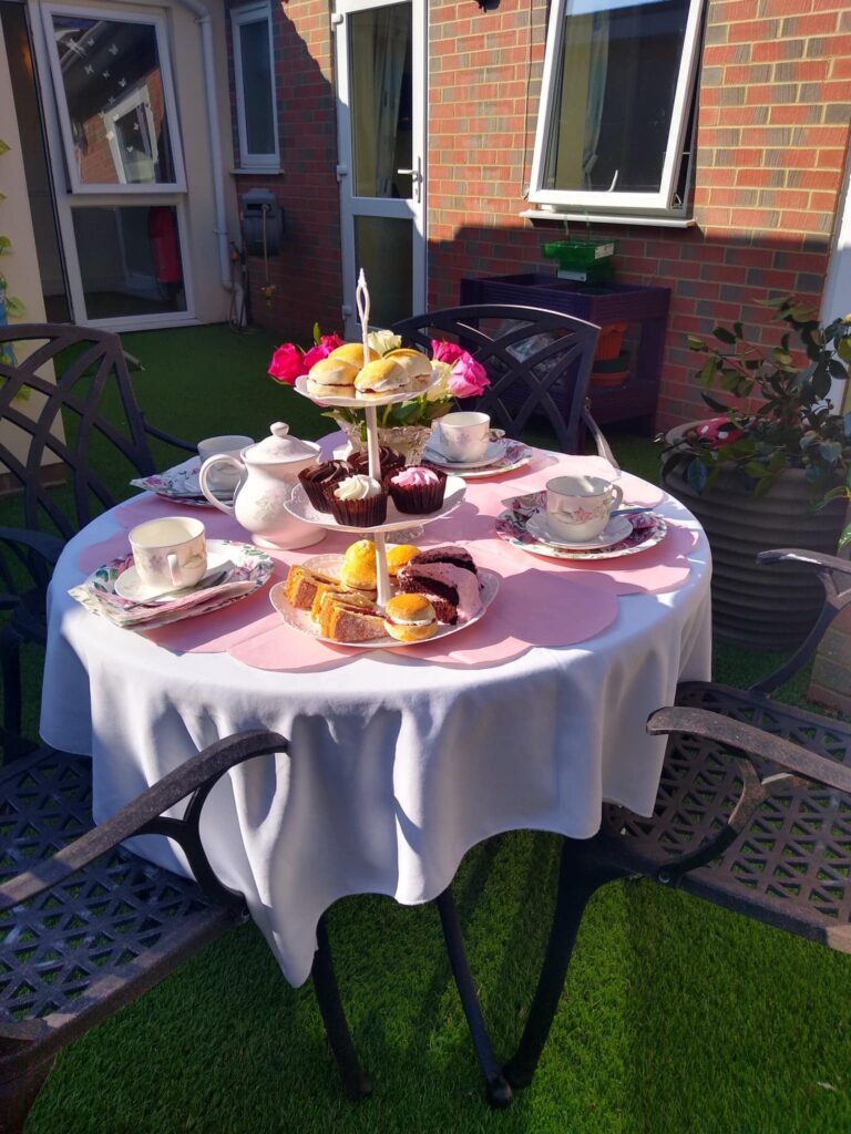 Residents enjoying afternoon tea outdoors at ManuCourt care home